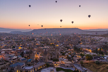 Early morning aerial view of hot air balloons above Goreme village in Cappadocia, Turkey