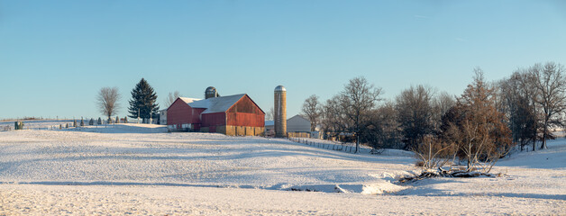 Amish Farm with Red Barn Sitting on a Snow Covered Hill In Holmes County, Ohio - Powered by Adobe