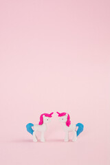Transvestite love at first sight. Unicorns with pink hair and blue tail on a pink background. Kids birthday wallpaper. Minimal concept of Valentine's Day, love, rainbow. Lgbt, lesbians or gay couple..