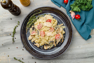 Pasta with chicken and mushrooms on grey wooden table top view