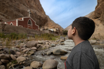 Fototapeta premium Kid looking at a church in a valley
