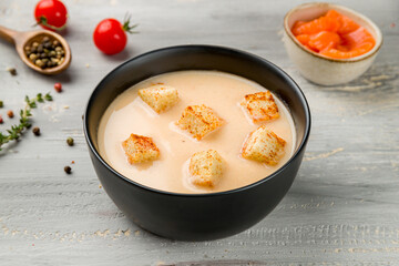 salmon cream soup on black bowl on grey wooden table