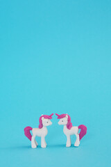 Love at first sight. Couple in love in pastel pink unicorns on a blue background. Kids birthday wallpaper. Minimal concept of Valentine's Day, love, rainbow. Lgbt lesbians.