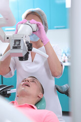 Dental treatment under a microscope. Professional examination at the dentist. A man at a dentist's appointment. Modern dentistry.
