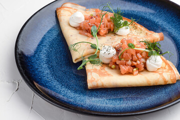 Pancakes with red fish, pancakes with fish on a white background, Russian cuisine