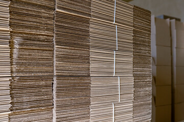 Folding cardboard boxes. Perforated sheets of corrugated cardboard are stacked on pallets. Packaging of finished products in industrial production.