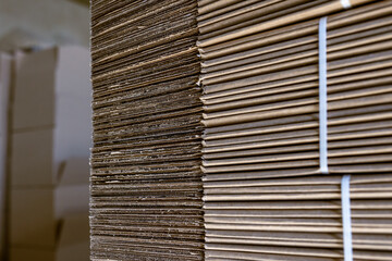 Folding cardboard boxes. Perforated sheets of corrugated cardboard are stacked on pallets. Packaging of finished products in industrial production.