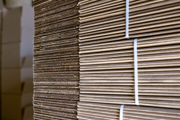 Folding cardboard boxes. Perforated sheets of corrugated cardboard are stacked on pallets. Packaging of finished products in industrial production.