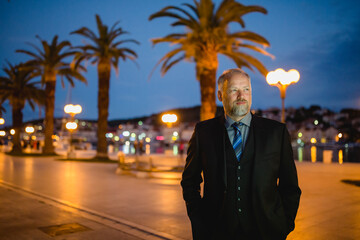 Mann im Anzug, Ufer-Promenade mit Palmen, blauer Himmel