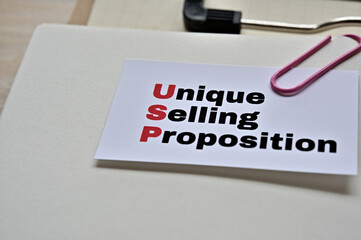 A piece of paper clipped to the edge of the notebook has Unique Selling Proposition.