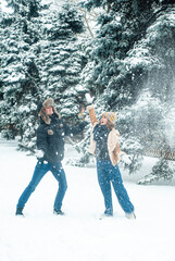 Man and woman playing with snow. Happy couple has fun outdoors.