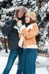 Fototapeta na wymiar Man and woman playing with snow. Happy couple has fun outdoors.