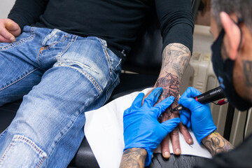 sesión de tatuaje en la mano