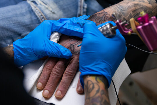 sesi&oacute;n de tatuaje en la mano