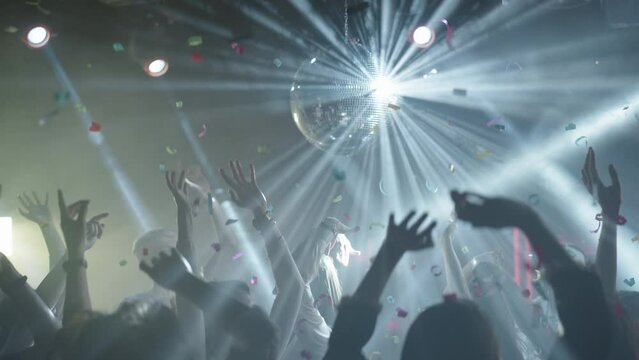 People dancing and jumping at disco. Evening enjoyment in music club. Nightlife, modern music and entertainment concept.
