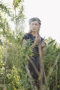 Woman in the Cannabis plant, Girl standing with Marijuana or Hem