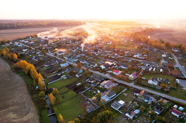 Country houses in the countryside, aerial view. Top view of roofs of green field with rural houses....