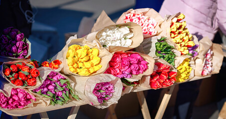 Bouquets of tulips, different colors of spring flowers for sale at city street. Colorful tulips at flower market. International women's day concept.