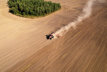 Field cultivating, aerial view. Tractor with disk harrow on plowed. Arable land ploughed and soil...