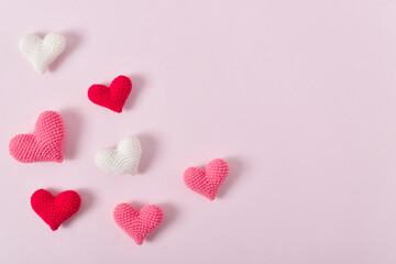 Background with pink knitted hearts for a festive Valentine's Day. Banner for February 14. Greeting card with hearts. Space for copying. Flat position, top view