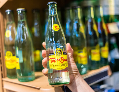 Los Angeles, CA/USA 6/1/2021 Shoppers hand holding a bottle of topo chico brand mineral sparking water in a supermarket aisle