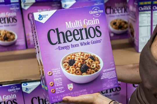 Sacramento, CA/USA 06/06/2021 Shoppers hand holding a family size package of Multi grain cheerios brand cereals in a supermarket aisle