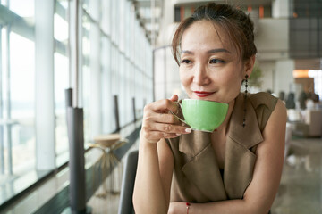 asian woman drinking tea in modern hotel restaurant
