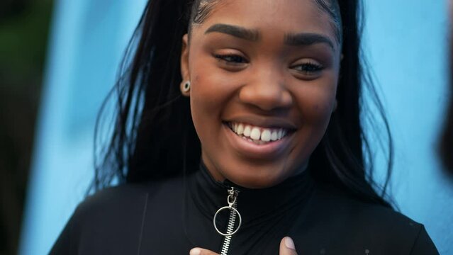 A black girl face laughing and smiling in conversation a teeen African girl close-up face