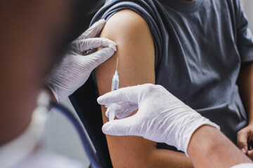 Close up of The arm of the patient who is being injected with vaccine or antibodies on his arm