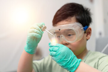 child use dropper in tube for education in learning laboratory and research with fun in chemical technology and biology like scientist