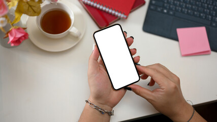 Obraz premium A smartphone white screen mockup in a female's hand