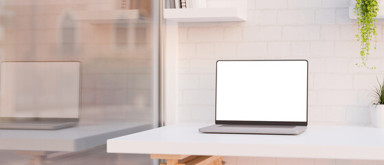 Modern office workspace with laptop computer white screen mockup