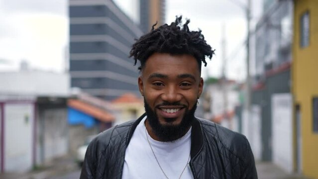 A happy young African man walking in urban street going forward