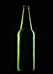 green beer bottle on black background