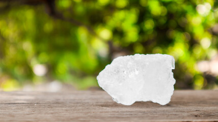 Crystal clear alum cubes or Potassium alum on brown wood plank. Chemical compound substance. Concept for beauty , spa and underarm treatment industrial. 