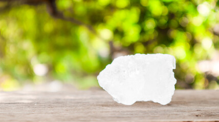 Crystal clear alum cubes or Potassium alum on brown wood plank. Chemical compound substance. Concept for beauty , spa and underarm treatment industrial. 