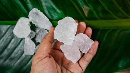 Crystal clear alum cubes or Potassium alum on palm. Chemical compound substance. Concept for beauty , spa and underarm treatment industrial. 