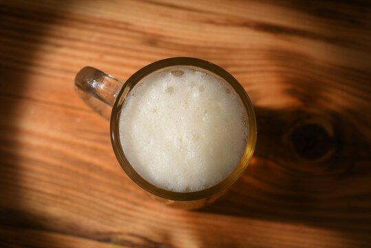 top view photo of beer glass on wood table 