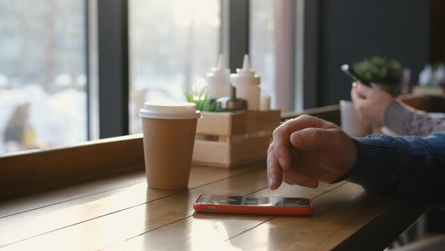 Close-up Macro: Person Using Smartphone, Browsing through Pictures on Social Network Wall. Finger Scrolling Social Media App Feed: Travel, Animals, Food. Mock-up Application Design. A man sits in a