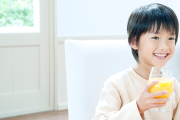 Fototapeta premium オレンジジュースを飲む男の子