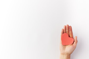 Valentine's Day, a woman's hand holds a red heart out of paper. Top view. Copy space. Place for text.