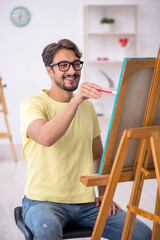 Fototapeta premium Young man enjoying painting at home