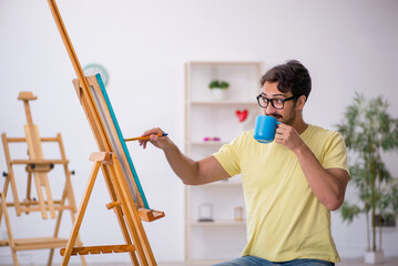 Young man enjoying painting at home