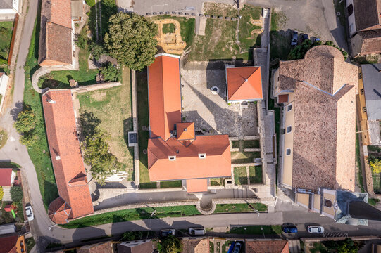 Aerial top down bird eye view of Szaszvar medival castle and fortified manor house, with red roof, smi corcle tower and walls in Baranya country Hungary