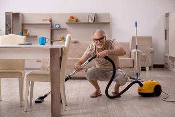 Old man doing housework at home