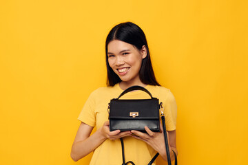 Charming young Asian woman with a black woman's bag in her hands Lifestyle unaltered