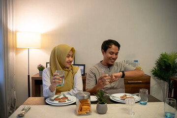 muslim couple waiting adhan to break the fast