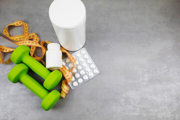 dumbbells on the background of pills. Healthy lifestyle. sports nutrition, doping - obrazy, fototapety, plakaty