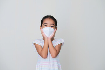 Asian kid showing happy expression while wearing medical mask during pandemic