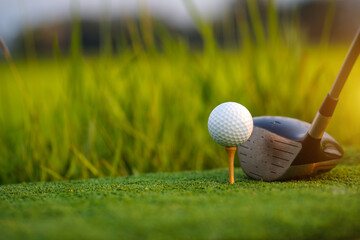 Golf club and ball on green grass ready to be struck on golf course background